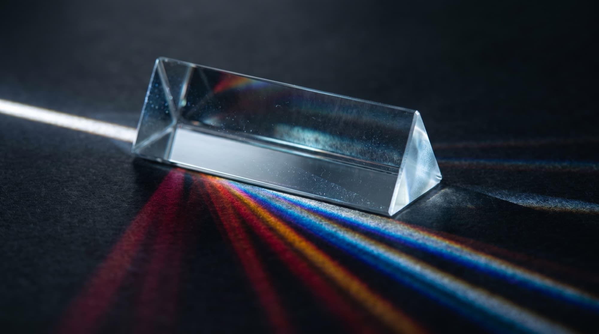 Un prisma descomponiendo la luz blanca en el espectro de colores de la marca Prisma